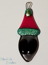 Load image into Gallery viewer, Fused glass Alien in a Santa hat ornament red green holiday bauble
