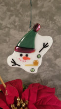 Load and play video in Gallery viewer, melted snowman ornament with green hat with dichroic red/green trim, dichroic green buttons, corncob pipe. winter time, holiday decoration, ornament
